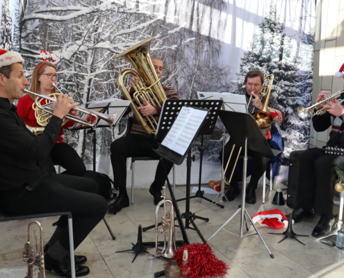 A Northern Chamber Orchestra quartet playing brass instruments wearing Santa hats.