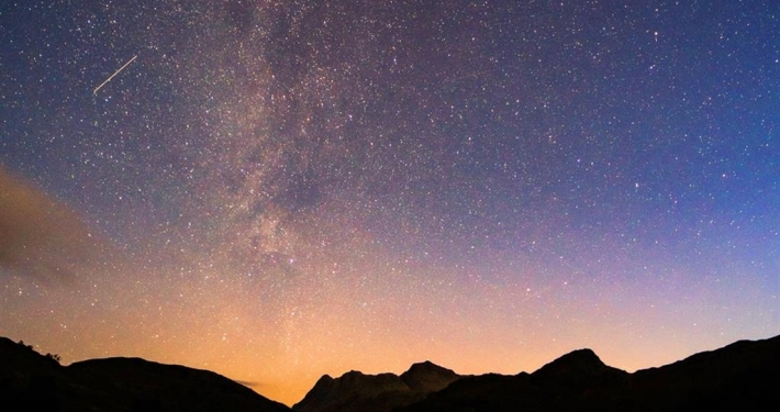 A starry night view over mountains.